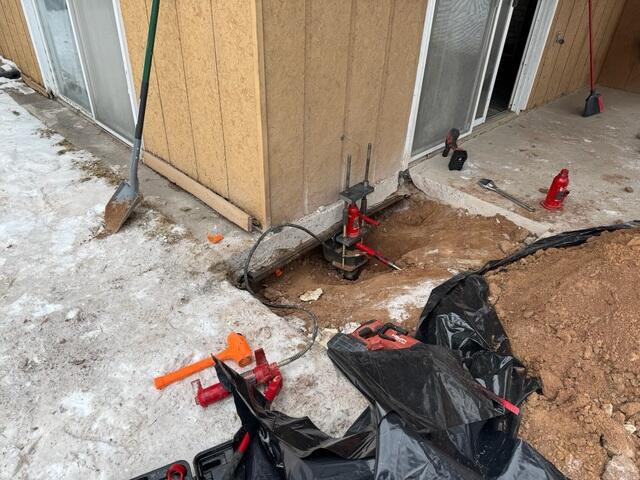 During: Our crew successfully secured the Helical Pier on the outside of the home.