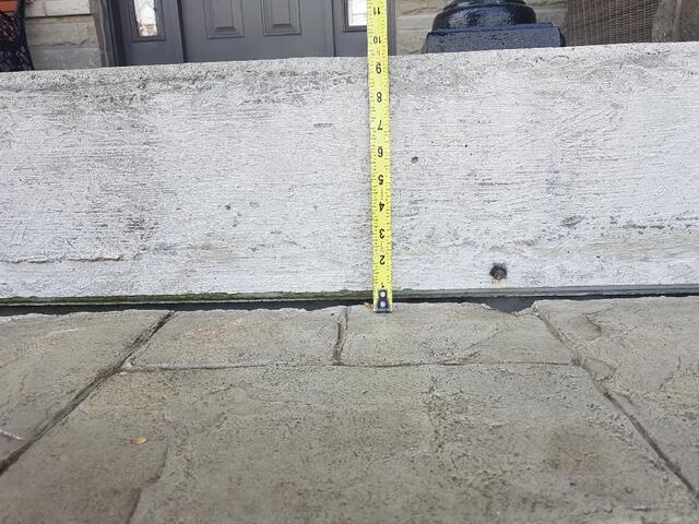 A detailed shot using a measuring tape to show the exact depth of the settlement. Identifying the precise amount of lift needed ensures the walkway is returned to its original, level position.