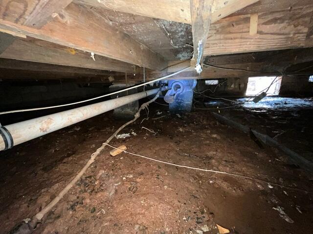 Before encapsulation, the crawl space had exposed dirt, high moisture levels, and a humid, musty environment.