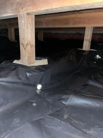 Underneath the 6 Mil Black Plastic Vapor Barrier, lies all the piping we installed to collect all water intrusion. The pipes route the water to the SuperSump, and then the pump sends all water safely away from the home via a buried discharge line.