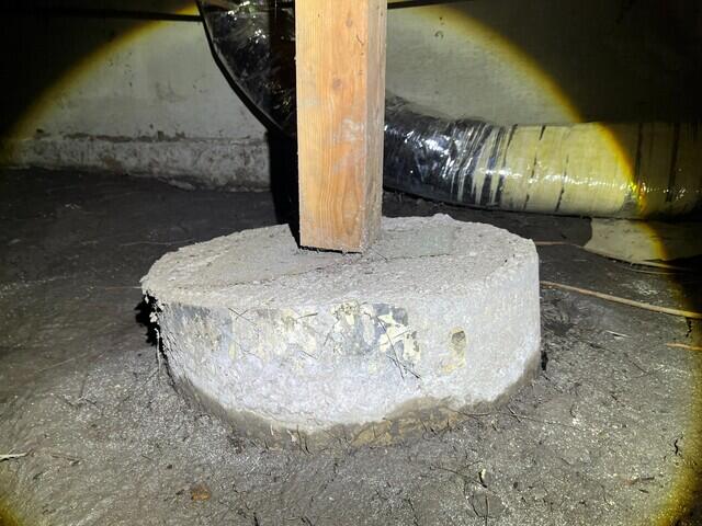 Due to ground erosion, the concrete footing shifted, causing the wooden pier to float over top.