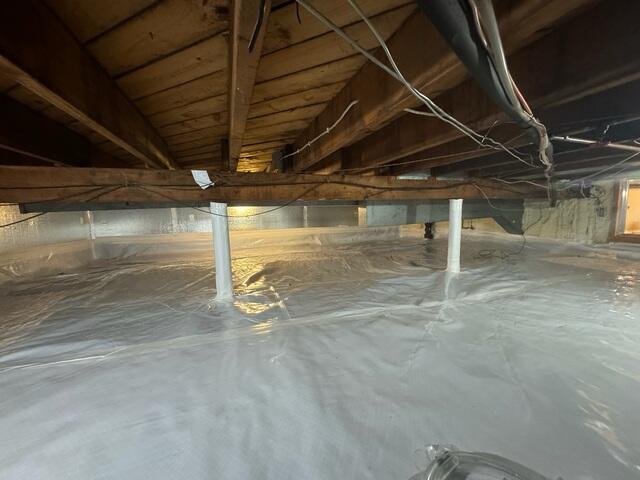 CleanSpace vapor barrier fully encapsulating the crawl space floor and walls.