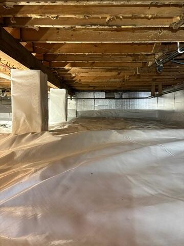 Fully-encapsulated crawl space featuring CleanSpace vapor barrier and SilverGlo wall insulation, transforming a damp dirt-floor area into a clean, dry, energy-efficient space ready to protect the rental property for years to come.