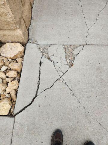 Before: Our Design Specialist, Dylan, recommended repairing the damaged sidewalk to prevent tripping hazards.