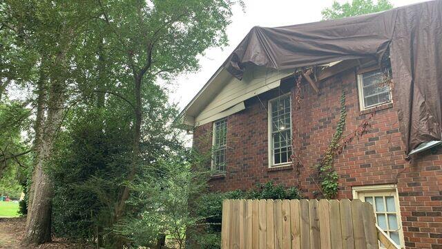 Gusting winds caused fallen trees to puncture the roof, weakening the property's structural integrity.