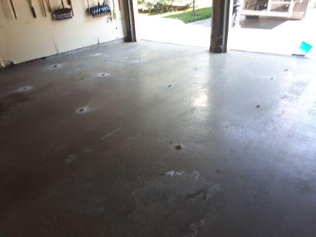 Final result of garage floor repair in Pickering: sunken concrete slabs have been lifted and stabilized using polyurethane concrete leveling. Tripping hazards and gaps are eliminated, and the floor is now solid and ready for vehicle use, with only small filled injection points visible.