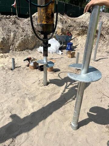 Installing helical pier 10"-12"-14" lead section with 14" extension in foreground