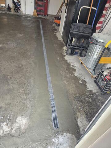 A TrenchDrain system is set to capture surface water before it could reach the basement floor and dircet it to the sump pump.