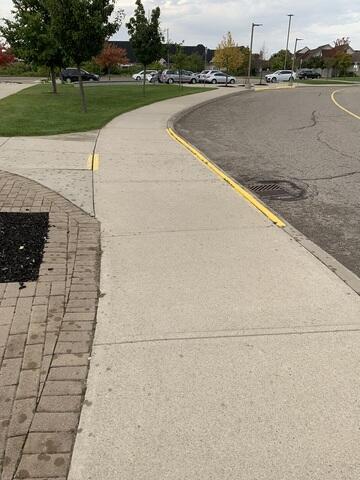 The yellow markings highlight a significant trip hazard where the concrete had settled. These uneven 'lips' created a dangerous barrier for the congregation, particularly for elderly members or those with mobility aids.