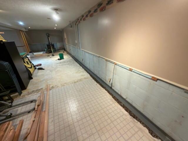 The crew removed the tile and drywall to waterproof the finished side of the basement as well.