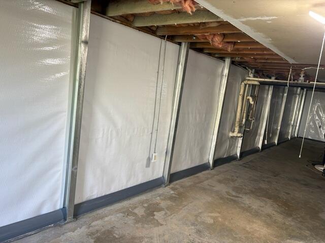 This was what the shearing wall looked like after we repaired it. The braces will stop this wall from moving and the waterproofing system at the bottom will keep the basement dry. No jackhammering needed for this wall repair system. Another note, normally we would create holes at the bases of the beams to allow water to filter through whatever type of drainage system we used. However, this was not needed as there is already room behind the braces along the bottom most row of block for water to channel through. We were able to use the shearing to our advantage in this regard.