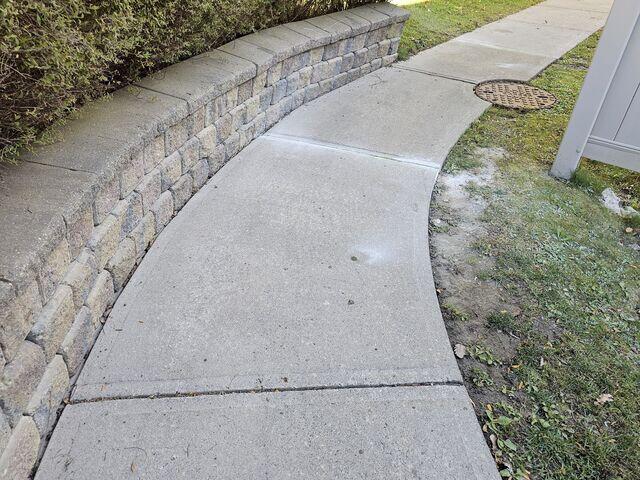 Following the stone retaining wall, the curved walkway is now perfectly aligned. Each slab has been carefully leveled, creating a smooth, continuous path that blends seamlessly with the surrounding landscape.