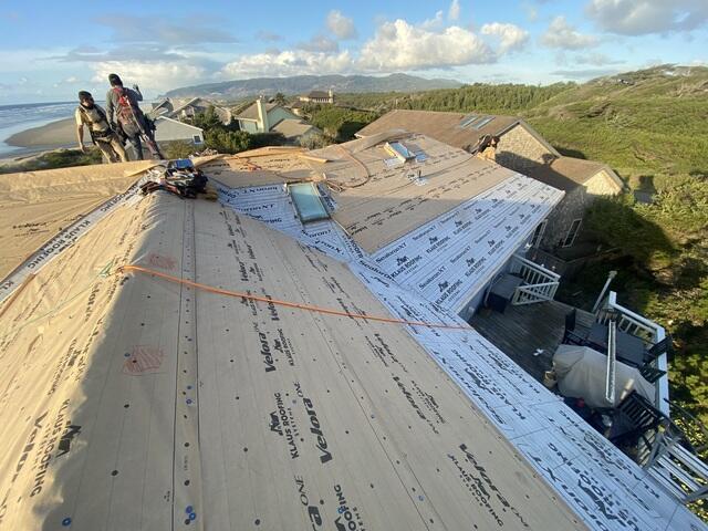 Full tear-off and removal of old shingles, reinforcing the structure with new decking where needed. Advanced sealing at all joints and vulnerable areas, plus ice & water protection at eaves, valleys, and roof penetrations. The wood deck is now prepped and ready for the new Atlantic Blue shingles with crisp white gutters and flashing