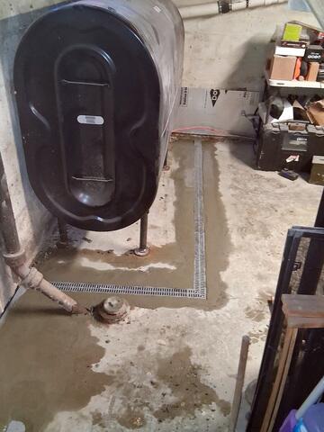 WaterGuard® Interior Drainage System installed along the perimeter to intercept incoming water at the foundation
TrenchDrain™ System installed around the oil tank to capture surface water in the problem area
