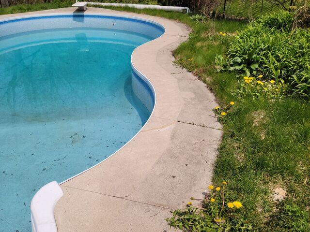 This shot highlights the severe settling along the pool's curved edge. You can clearly see how the concrete has pulled away from the liner track, creating a significant trip hazard and allowing even more water to reach the vulnerable soil underneath.