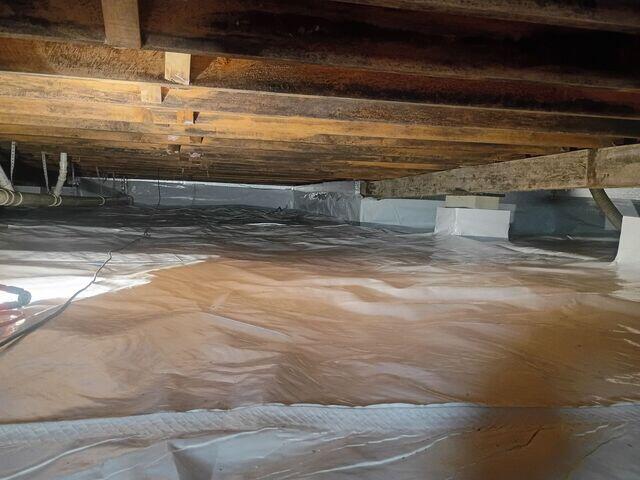 This crawl space once had a hard time at stopping moisture. A big reason why was because ground water often flooded the space. We made sure to install a proper waterproofing system underneath the vapor barrier to keep the vapor barrier protected from floods.