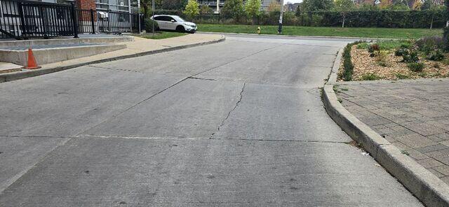 Looking back toward the street, it's clear how many cars and people rely on this space. For a busy residential complex in Toronto, having a smooth transition is vital for accessibility, especially for seniors and parents with strollers who need a reliable surface to navigate.
