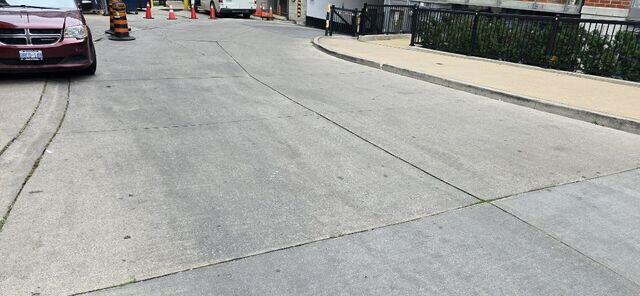This perspective shows the high-traffic entrance where residents and families enter the building every day. From this distance, you can see how the settlement had begun to pull the slabs apart, creating an uneven and uninviting path for both vehicles and pedestrians.