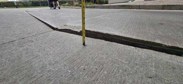 The tape measure reveals the true extent of the danger: a nearly 4-inch ledge. This isn't just a bump-it's a massive trip hazard and a liability for the property. This photo highlights the deep void underneath that we filled with our high-density polymer to bring the slab back toward a safe, level position.