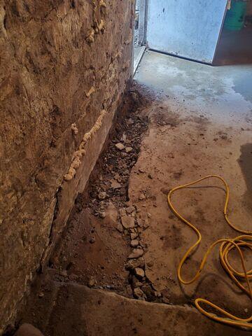 The crew carefully digs a trench around the basement perimeter to install the WaterGuard and TrenchDrain systems.