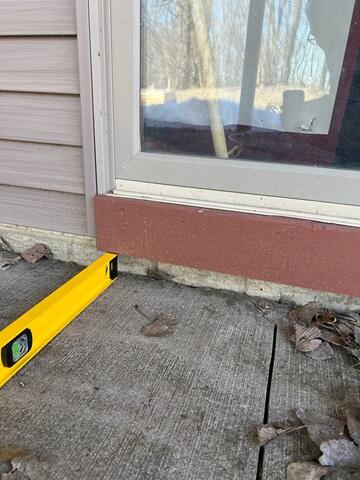 A close up of how far the slabs have sunken in front of the door