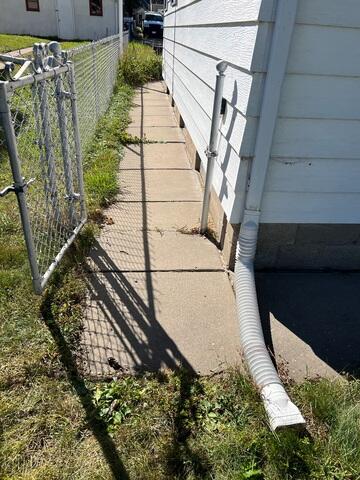 The concrete along the side of the home, showing signs of significant sinking