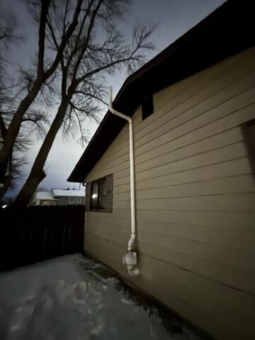 The exterior where the fan can be seen and additional piping that leads above the roofline.
