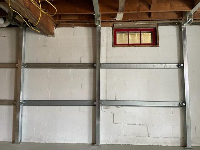 Zinc-coated steel beams custom fit to the basement height
Secure anchoring to both the basement floor and floor joists above
Designed to stop further inward wall movement immediately
An adjustable system that can be tightened over time for potential wall improvement
