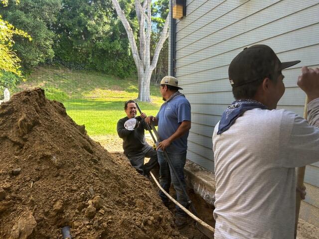 Before photo of back yard being dug out to the foundation, before french drain system install.