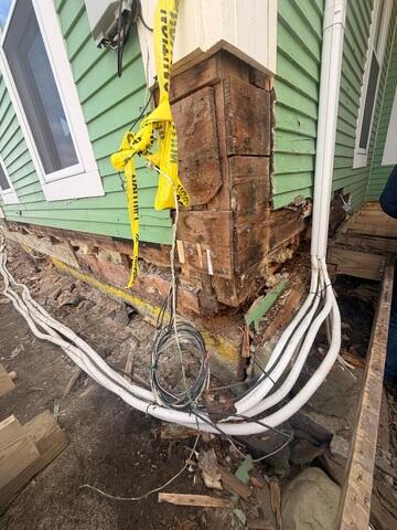 Extensive wood deterioration along the lower exterior wall behind the porch in Roxbury, Vermont.