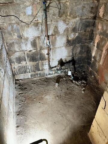 The well room showing signs of water leaks along the walls and edges of the floor