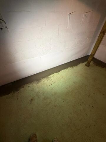 The crew re-concretes the floor once the system is installed. There is a small gap between the wall and the trench that allows water seepage from the walls to drain through.
