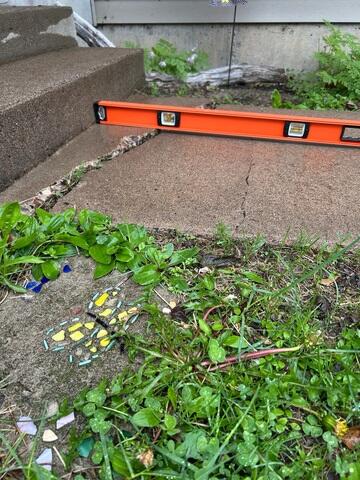 A close up of the front walkway where a crack has formed and the slabs began sinking