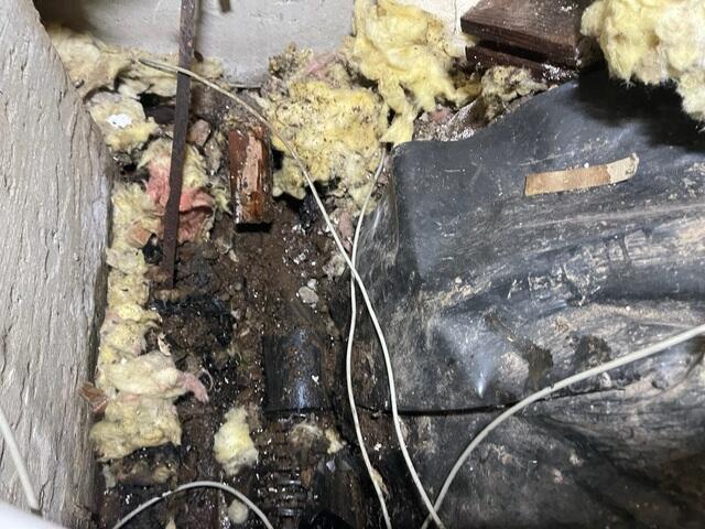 Water near the foundation and soaked debris.