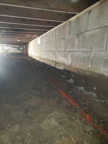 SmartPipe is installed beneath the crawl space substrate to collect and drain water via the sump pump system.