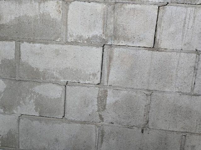 A close up of the stair step cracks that have formed along the foundation walls