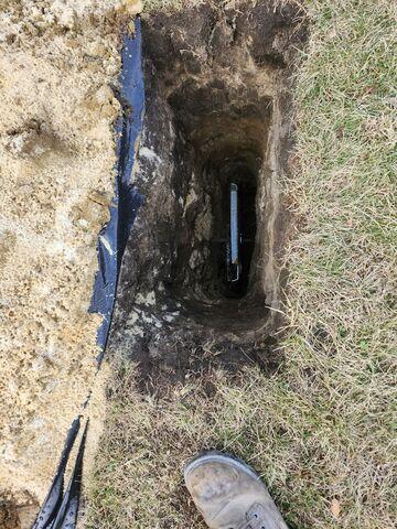 The earth anchor placed in the hole and connected to the interior wall plate