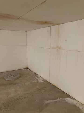 The basement where water leaks can be seen along the walls and flooring