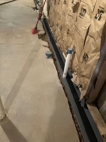 Our crew in the process of installing WaterGuard along the perimeter of the basement