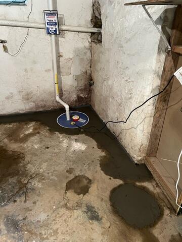 One of the two newly installed SuperSump systems designed to help remove collected water efficiently from the basement. Paired with the interior drainage system, the sump setup provides dependable water management for the homeowner.