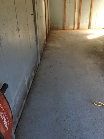 The area where water stains can be seen along the edges of the wall and floor