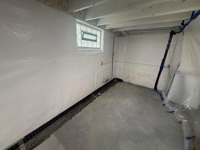 The crew digs a trench in the basement interior to install the WaterGuard system.