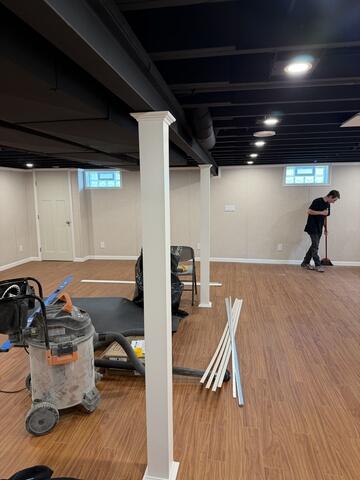 Our installation team puts the finishing touches on this newly remodeled basement, carefully cleaning up tools and work areas before project completion. Attention to detail and a thorough cleanup ensure the homeowner can immediately enjoy their new finished space the moment the project is complete.