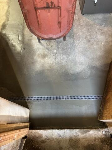 TrenchDrain was installed to collect surface water across an open floor area. This is especially helpful in spots where water can enter or travel across the floor before reaching the perimeter drainage system. The drain captures that water and directs it into the waterproofing system.