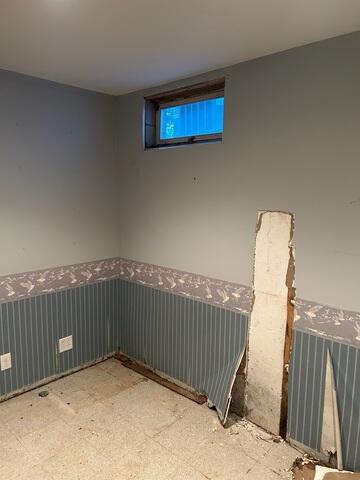 Removing the finished wall coverings revealed the extent of the hidden water damage. Materials like paneling and wallpaper can hide moisture problems for years, making them difficult to spot. The discoloration along the bottom of the wall is a clear sign that water has been seeping into the basement for much longer than the homeowner realized.