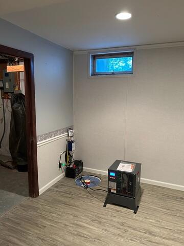 In this finished photo, you can see how everything comes together to create a clean, dry, and comfortable living space. The EverLast Wall Restoration system provides a bright, durable wall finish, paired with beautiful basement flooring designed to handle below-grade conditions. The SuperSump system with UltraSump 4 battery backup is in place to provide reliable protection against water intrusion, while the SaniDry Sedona dehumidifier helps maintain low humidity levels and improve overall air quality.