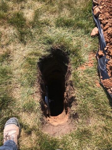 The earth anchor is placed in the hole and connected to the interior wall plate
