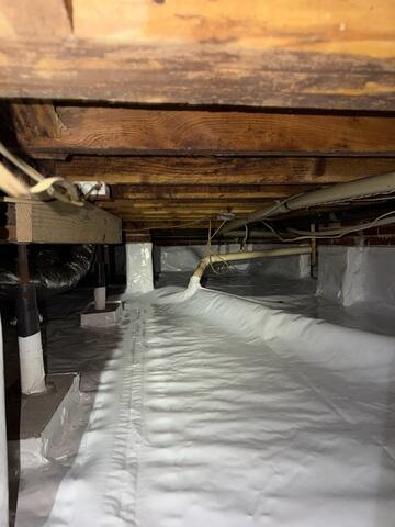 Crawl Space Encapsulation System - The crew fully encapsulated this crawl space with our CleanSpace Vapor Barrier System. CleanSpace Vapor Barrier System provides a durable and effective solution for moisture control in crawl spaces. It helps to prevent mold and mildew growth, improve indoor air quality, and reduce energy costs by creating a barrier against moisture and humidity.