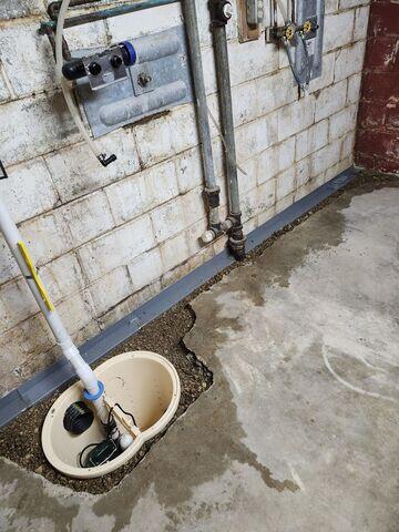 Our crew drilled a sump pit and the edges of the floor. Then, WaterGuard and components of the sump pump were placed, and the areas were backfilled.