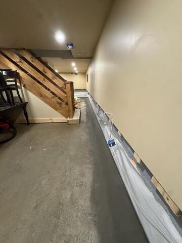 A below-floor interior drainage system is installed around the basement perimeter to capture water and direct it toward the sump pump system. Installed along the foundation walls to intercept wall water and direct it downward into WaterGuard while providing a clean, bright wall surface behind the finished walls.